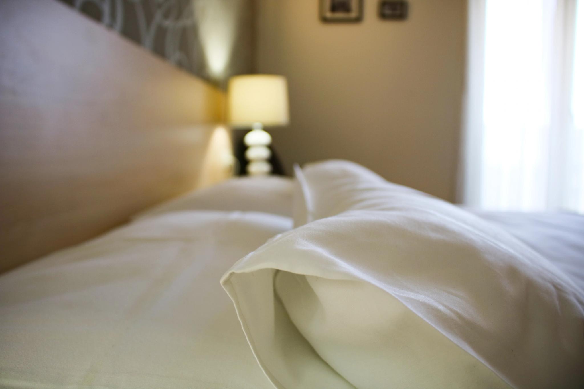 Lit et lampe de chevet dans une chambre cosy de l'hôtel 4 étoiles en Balagne